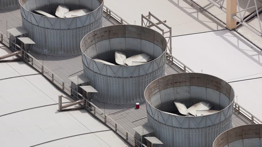 Cooling tower fans spinning on a rooftop in Dubai