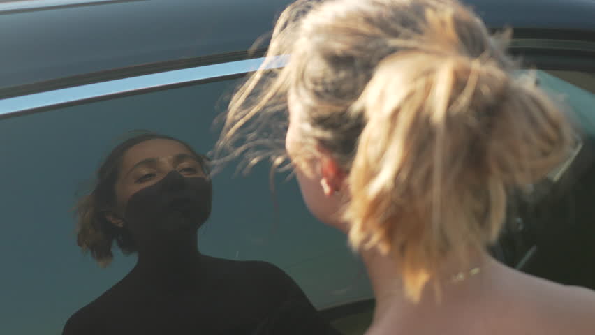 Woman, Car, Reflection - A woman stands by a car with another woman reflected in the window.