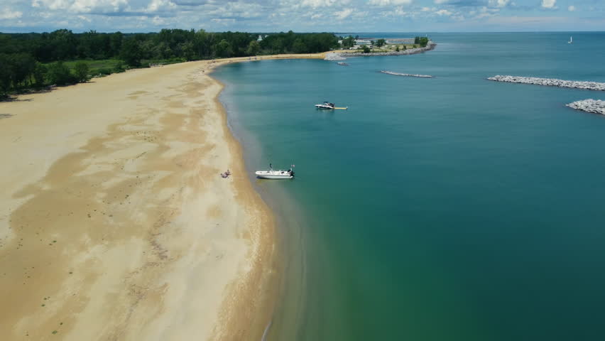 Aerial view of a sandy beach with boats near the shore. A serene aerial view of a sandy beach with clear blue waters. Lake Michigan, Illinois, Beach
