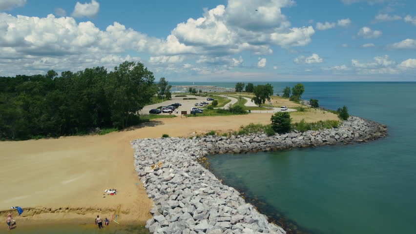 Scenic coastal parking lot with a view of the bay. A scenic view of a coastal parking lot with cars parked near the shore.