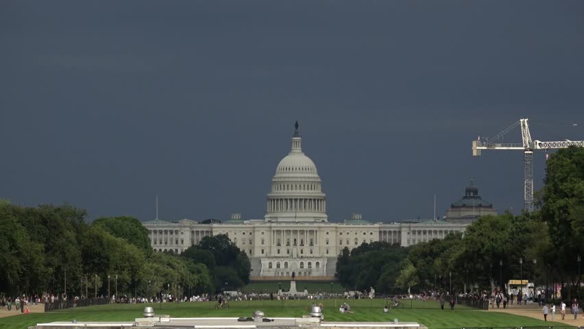 Time lapse of the U.S. Capitol illuminated by the sun on a mostly  cloudy day.