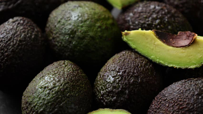 Avocado fruit, closeup of avocados fruit on black 