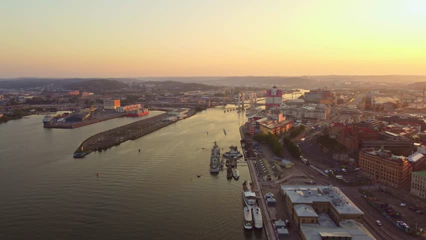 Gothenburg skyline at sunrise, aerial view, old town, the river and the Hising bridge (Hisingbron), clear sky, orange and yellow hues.