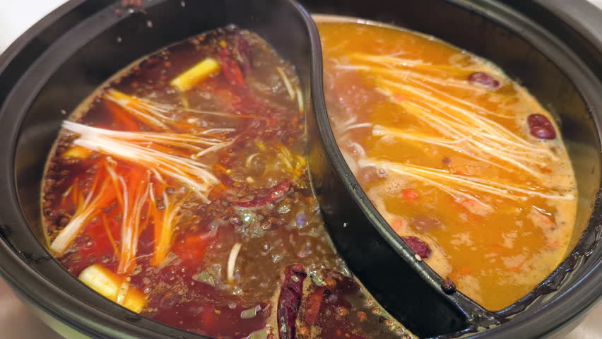 Mala soup is in a hot pot, with a slice of beef and pork beside the mala hotpot. Original mala spicy hot pot in China