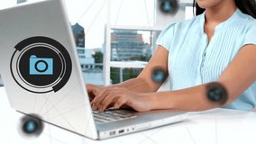 Animation of media icons over biracial businesswoman using laptop. Global business and digital interface concept digitally generated video. - Powered by Shutterstock - Get 15% off with code: PIKWIZARD15