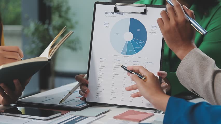 Financial analysts analyze business financial reports on a digital tablet planning investment project during a discussion at a meeting of corporate showing the results of their successful teamwork.