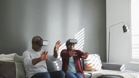 Animation of media icons over biracial couple using vr headsets at home. Technology and digital interface concept digitally generated video. - Powered by Shutterstock - Get 15% off with code: PIKWIZARD15