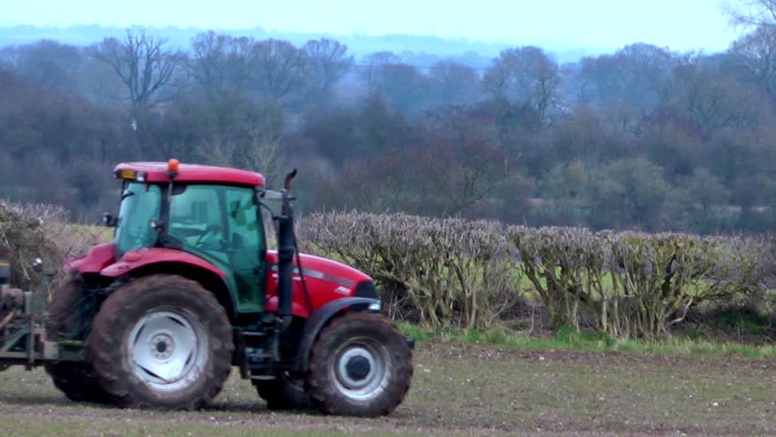 Tractor Spraying Fertilizer Onto A Crop Of Winter Wheat - Staffordshire, England