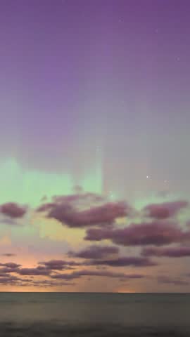 Blurry aurora borealis northern lights green pink color night abstract background vertical video. Estonia 2024