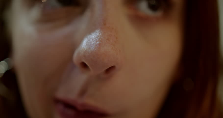 An extreme close up of a woman's nose, mouth, and freckles. Great for beauty and skincare projects.