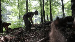 Soldiers digging trenches in a dense forest. A group of Ukrainian soldiers dig trenches in a dense forest as part of field work or military exercises. - Powered by Shutterstock - Get 15% off with code: PIKWIZARD15