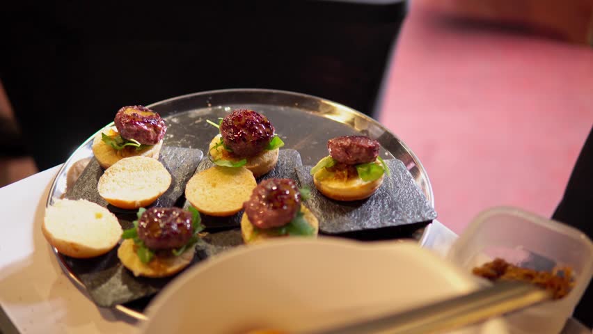 Professional waiter pouring mustard on burgers while working on a small business restaurant	
