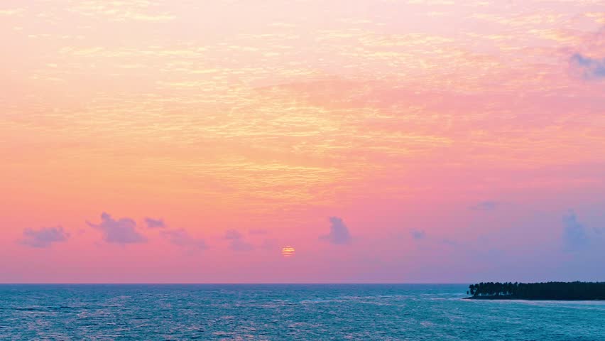 Orange sun over the ocean. Pink-orange sunset sky with clouds. Sea waves with sun reflection. Calm morning seascape. Evening sky for meditation. Horizon over water. Breathtaking sunset over the sea.