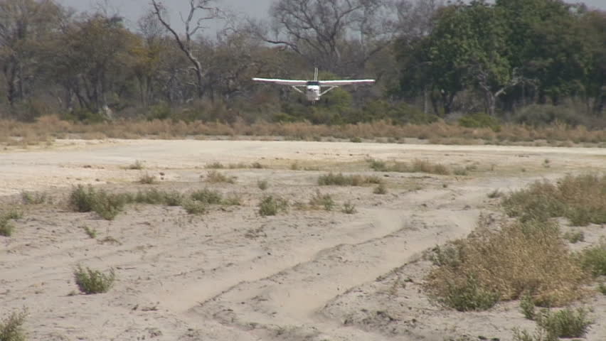 A bush plane lands on a dirt runway in Africa. Sony V1U.  