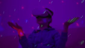 Girl Using Virtual Reality Headset And Looking Around At Interactive Technology With Colorful Illumination. VR Entertainment Immersive. Girl Wearing VR Headset in World of Virtual Reality Interacting. - Powered by Shutterstock - Get 15% off with code: PIKWIZARD15