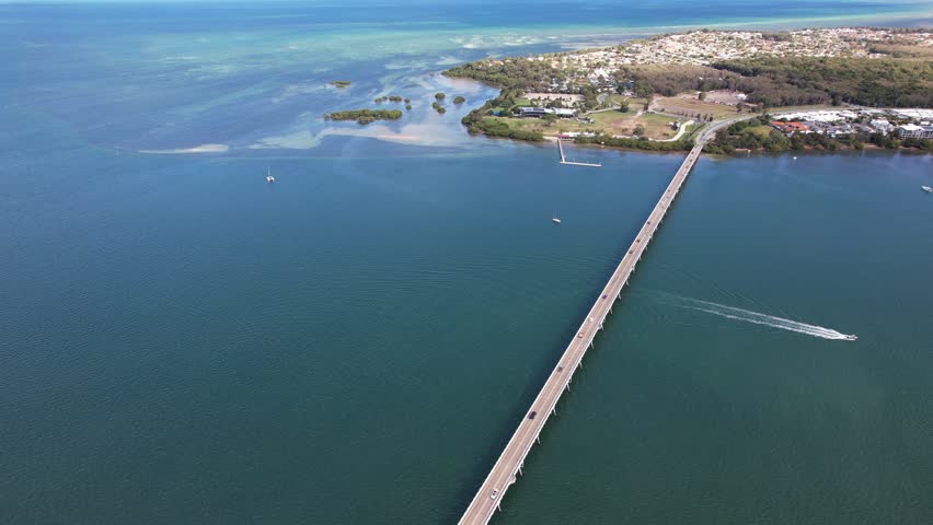 Bribie Bridge Spanning Pumicestone Channel In QLD, Australia. Sandstone Point In Background. aerial pullback shot