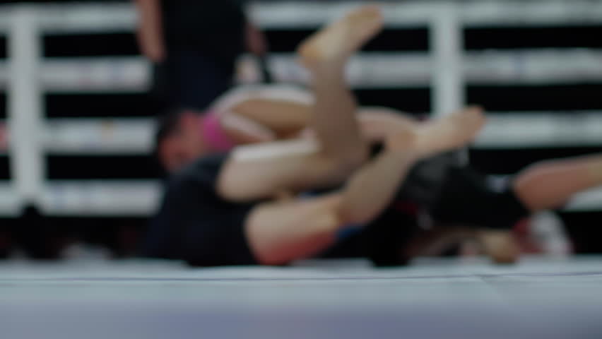 Two professional wrestlers are competing in a championship match.  One wrestler is pinning his opponent to the mat, hoping for a win