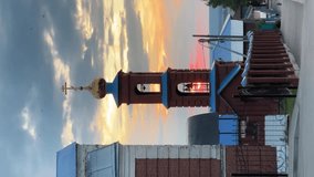 View of the chapel, with the bells of the Orthodox church, is surrounded by birds flying against the backdrop of a red summer sunset sky. Vertical - Powered by Shutterstock - Get 15% off with code: PIKWIZARD15
