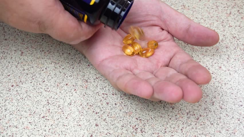 Medicinal tablets are poured out of a medicine bottle onto an open palm. Suitable for advertising medicines, dietary supplements and treatment of diseases.

