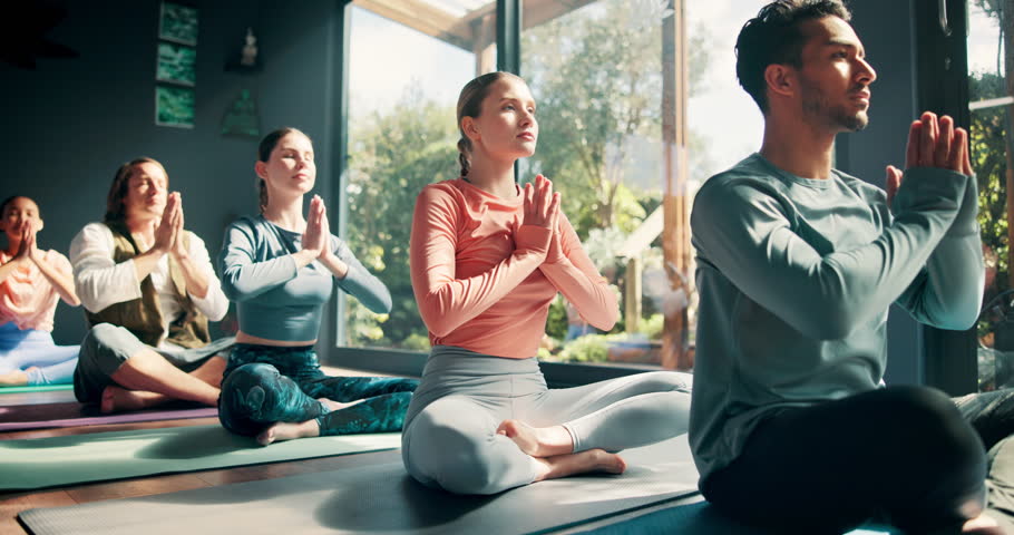 Yoga, group and meditation with namaste in studio for holistic wellness, mindfulness or spiritual healing on floor. People, diversity class or praying hands for mental health balance, peaceful or zen