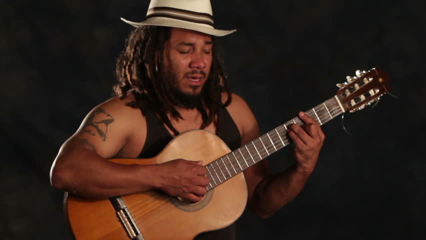 Rastafarian man playing classic guitar