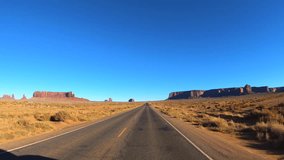 POV vehicle driving road trip sandstone cliffs Monument Valley landscape arid climate Arizona Utah America travel tourism - Powered by Shutterstock - Get 15% off with code: PIKWIZARD15