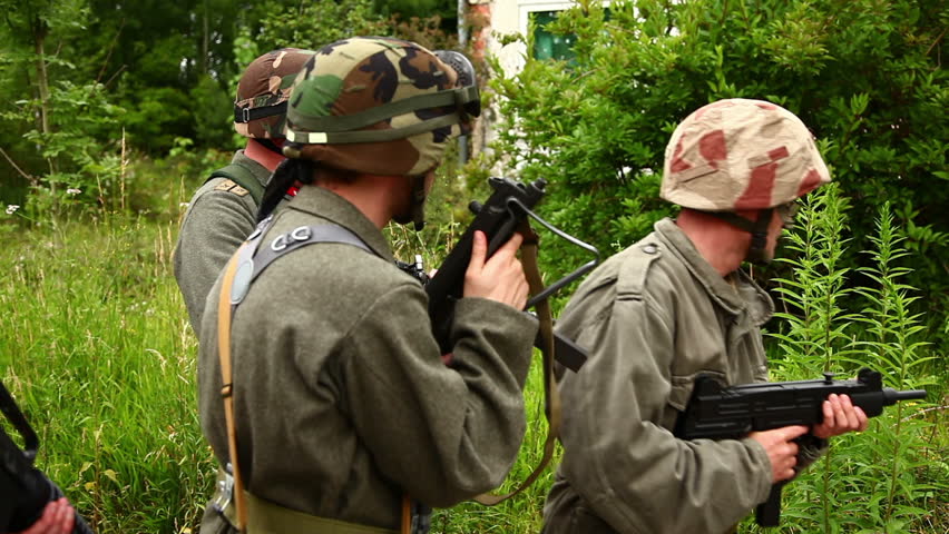 Soldiers storming into building in forest