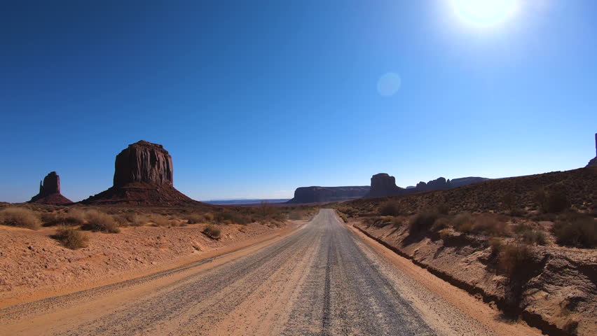 POV drive dramatic rock formations Monument Valley towering buttes a travel and tourists bucket list Arizona