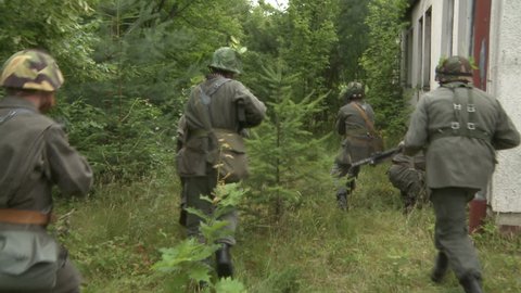 Soldiers running through forest – Stockvideo