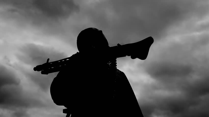 Silhouettes of soldiers in front of dark sky