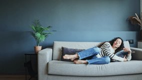 Woman arriving tired from the day lies down on the sofa and relaxes in a modern living room. Woman relaxing on sofa with cozy comfort at home - Powered by Shutterstock - Get 15% off with code: PIKWIZARD15