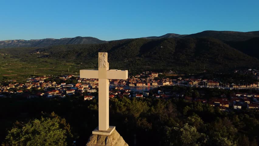 White Cross of Stari Grad (Hvar, Croatia) with the sunset in the background with many drone shots