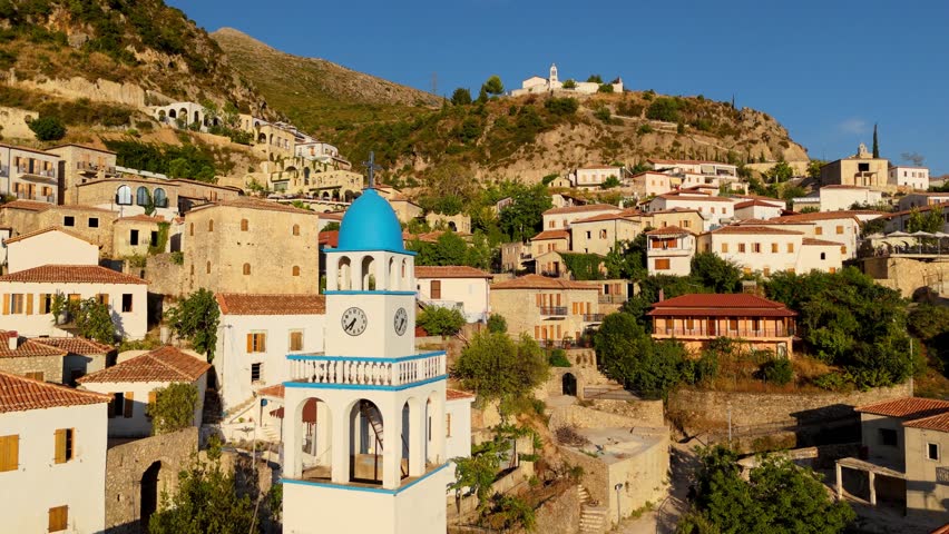 The ancient town of Dhermi, Albania, with a blue-domed clock tower nestled in the mountains