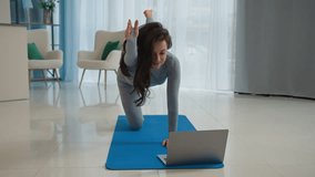 Slim woman Caucasian girl in sportswear stretching watching fitness video tutorial online laptop home workout learn exercise female fit athlete practice asana yoga class sport pilates in living room - Powered by Shutterstock - Get 15% off with code: PIKWIZARD15