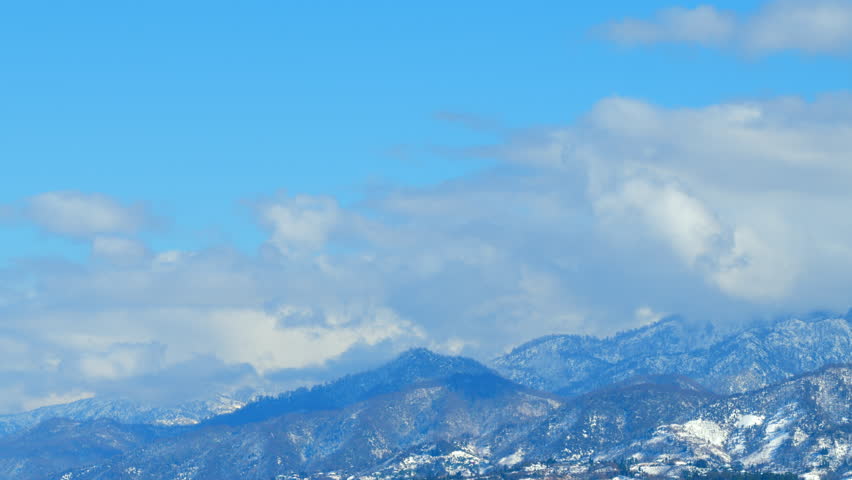 Snowy Fairy Tale Mountains With Blue Sky And Opposite Direction Clouds. Sunny Winter Day. Timelapse.