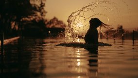 Beautiful woman bathing in swimming pool, waving her wet hair, silhouette. Sunset time and graceful female figure against sky in contour light, relaxation and pleasure in luxury hotel, enjoy life - Powered by Shutterstock - Get 15% off with code: PIKWIZARD15