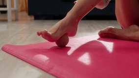 Close up unknown woman girl female massaging feet ball equipment foot leg massage on foam sports mat release tension pain myofascial muscle relaxation exercise physical therapy indoor living room home - Powered by Shutterstock - Get 15% off with code: PIKWIZARD15