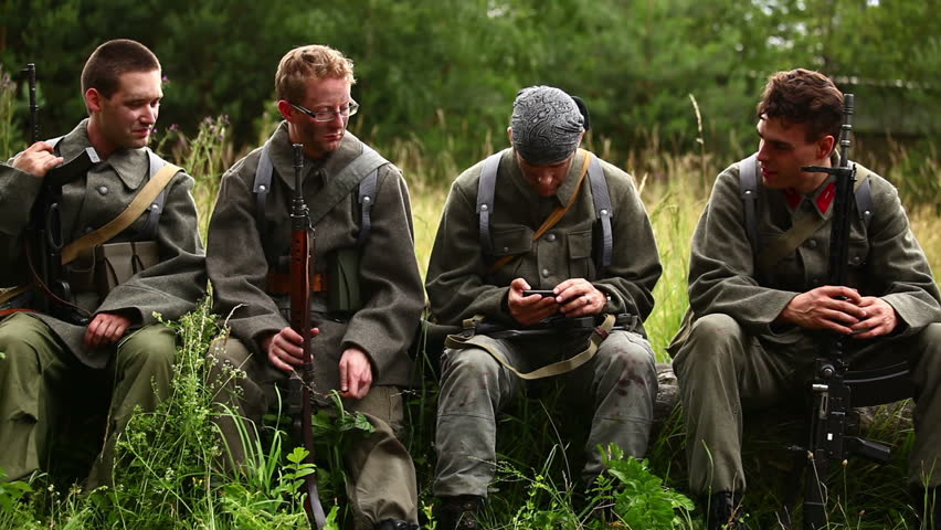 Soldiers sitting on tree trunk having break