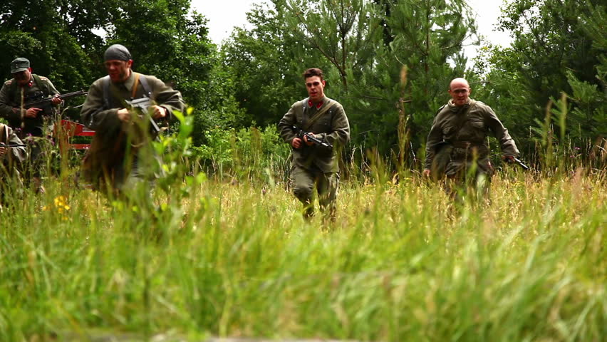 Soldiers running through high grass