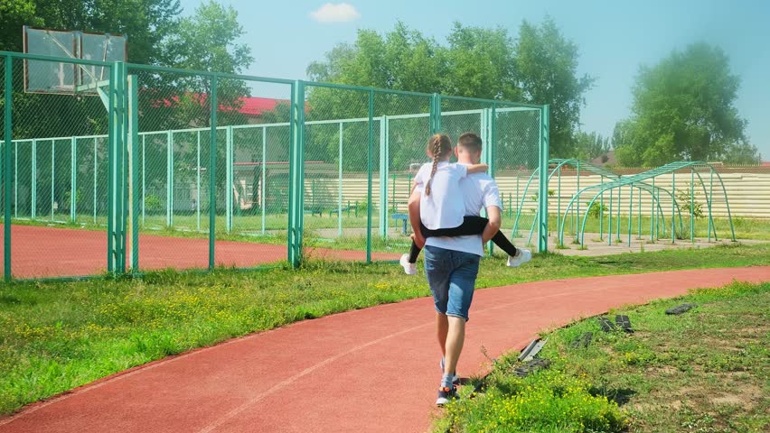 Father, daughter and piggyback fun in outdoor, adventure and play in sport ground for bonding or energy. Daddy, girl and plane game or flying together in outdoors, family and carrying kid for happines