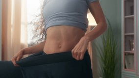 Happy joyful sporty Hispanic young girl woman female in big jeans showing thin body waist slimming fitness weight loss rejoicing progress celebrate dance beauty figure shape dancing indoors home room - Powered by Shutterstock - Get 15% off with code: PIKWIZARD15