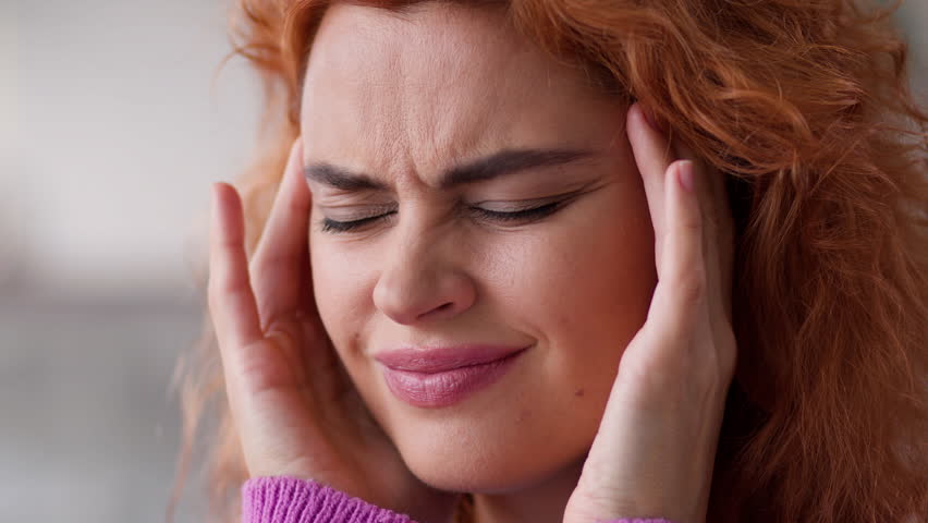 Close up ill sick painful migraine suffer Caucasian woman lady girl indoors at home female health problem trouble medicine painkiller headache massage temples head pain ache symptom hangover pressure