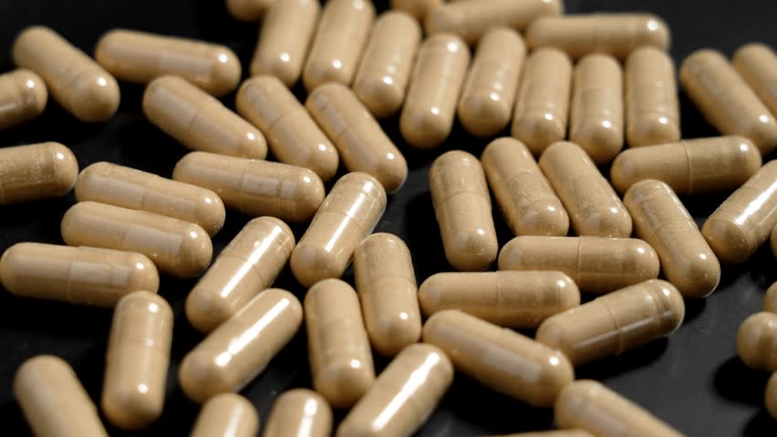 Medical Herbal Adaptogenic Ashwagandha Capsules in Black Plate. Dieting supplements. Rotation