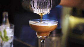 A bartender pours a Pornstar Martini with passionfruit from a cocktail mixer, while another bartender prepares a drink in the background. Great for vibrant, bar, and cocktail-making video projects. - Powered by Shutterstock - Get 15% off with code: PIKWIZARD15