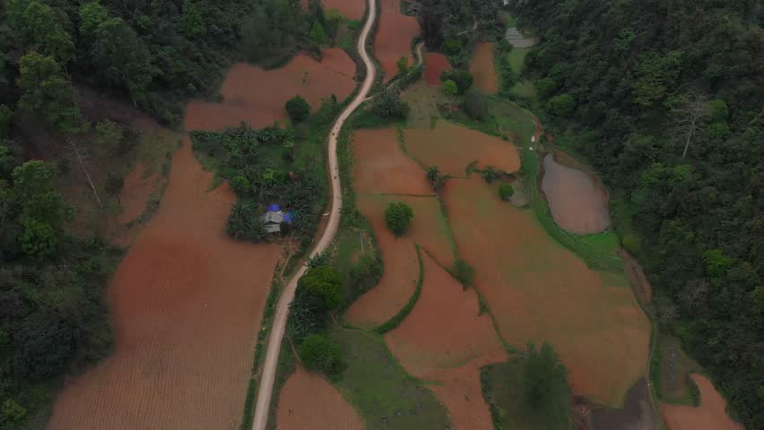 Aerial view of a serene valley surrounded by lush mountains and winding roads, Lang Son, Vietnam.