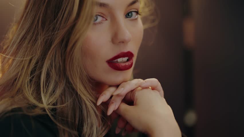 Close-up portrait of a woman with red lips and blonde hair, showing elegance and confidence. The image captures her beauty and style. Portrait Of Fashionable Young Beautiful Woman with Red Lips.