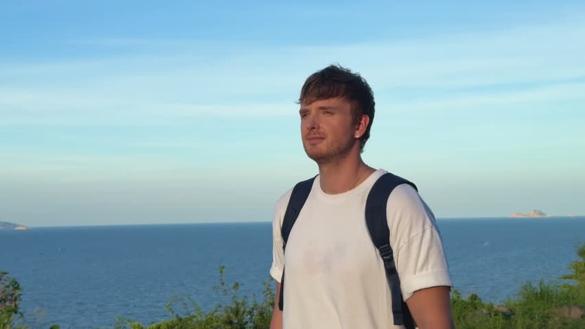 handsome man walks in the mountains, breathes fresh air, enjoys