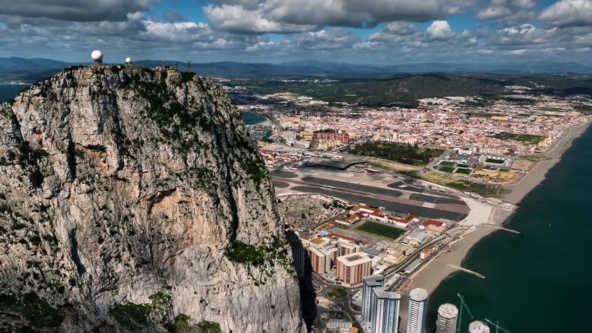 Aerial view of the iconic rock of Gibraltar overlooking the ocean and airport with a picturesque coastline, Gibraltar.