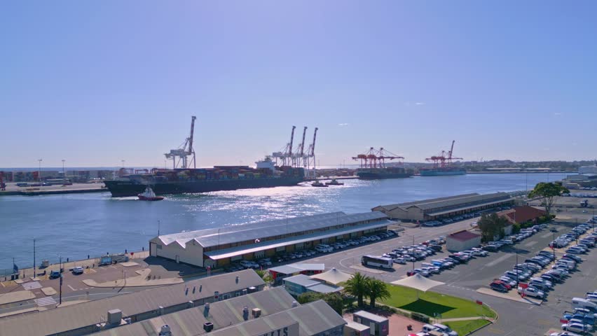 Fremantle Port with cargo ship and cranes on sunny day, Perth, Western Australia - aerial view