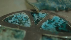 A close-up view of a mosaic cross with vibrant blue and green tiles, showing intricate details and textures - Powered by Shutterstock - Get 15% off with code: PIKWIZARD15